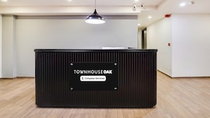 Un comptoir d’accueil avec une enseigne indiquant « Townhouse Oak » et « Service aux entreprises ».