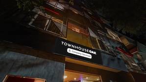 Un immeuble avec une enseigne indiquant « TOWNHOUSE OAK » et « Services d’entreprise ».