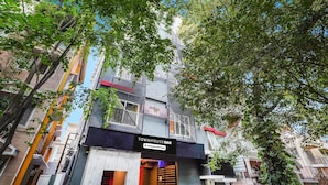 Un immeuble à plusieurs étages, sur lequel on peut lire les inscriptions « TOWNHOUSE OAK » et « Service assuré par l’entreprise ».