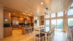 A spacious kitchen with wooden cabinets, a stainless steel refrigerator, and a dining area with a large table and chairs.