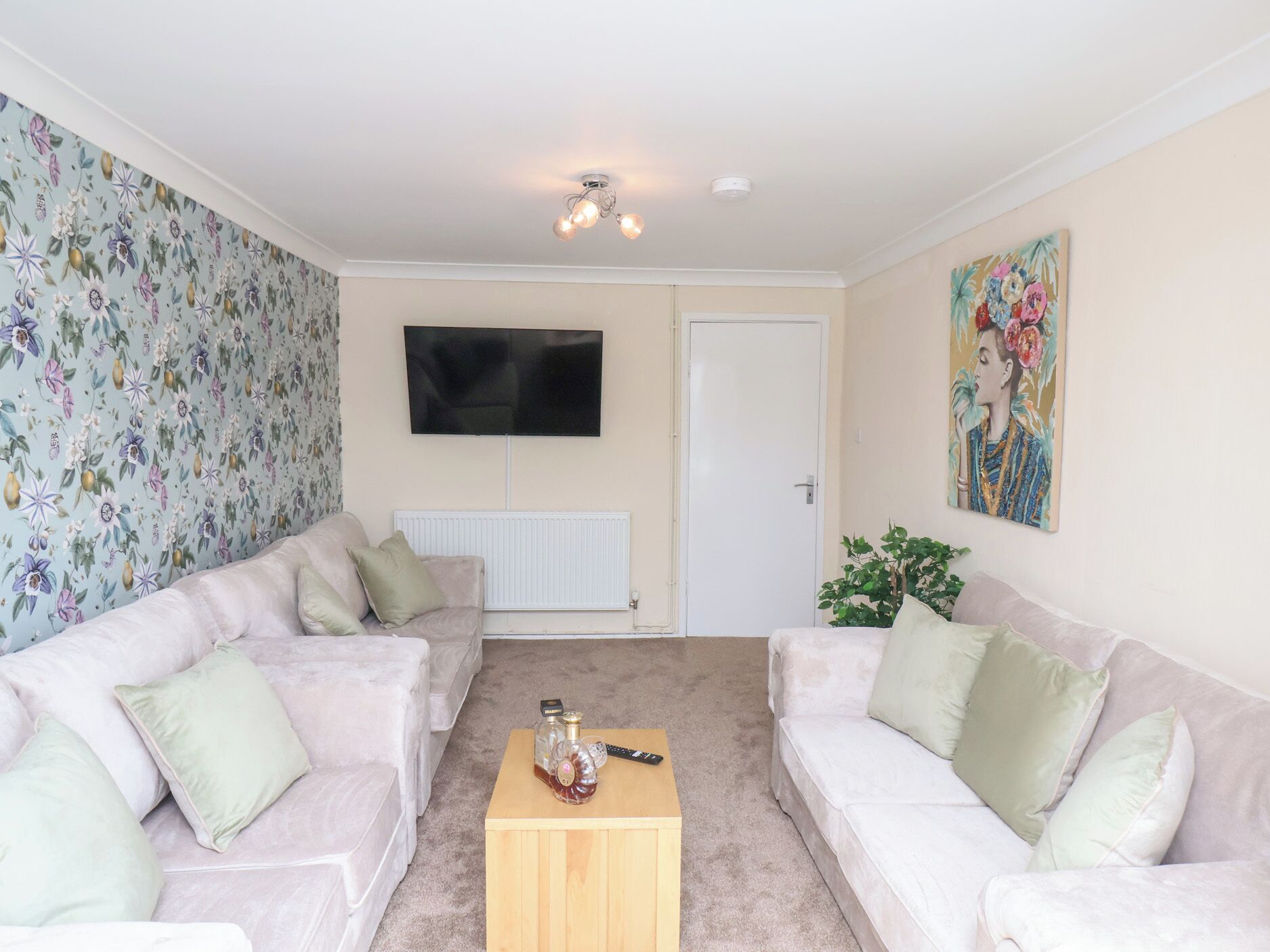 A living room with two sofas, a coffee table, a TV, and a door.