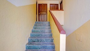 A staircase with marble steps leading to a wooden door. - Luxury Stays With Pool Near Calangute Beach (Calangute)