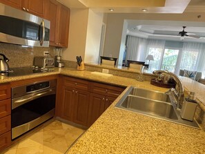 A modern kitchen with granite countertops, stainless steel appliances, and wooden cabinets.