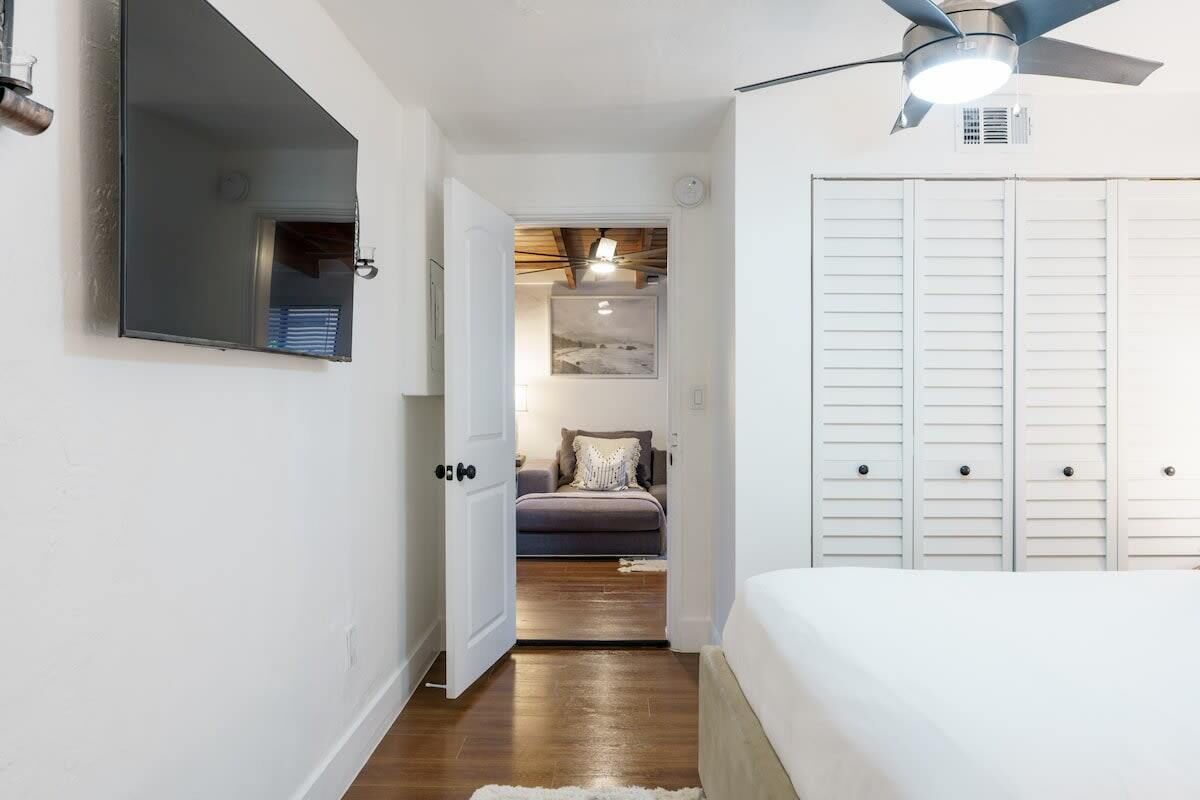 A bedroom with a bed, a ceiling fan, and a wardrobe.