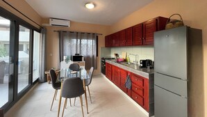 Cocina compacta con comedor, que incluye un refrigerador, microondas y cafetera.