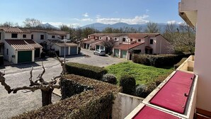 Un barrio residencial con casas, un coche y montañas al fondo.