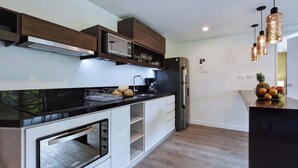 A modern kitchen with built-in appliances, wooden cabinetry, and pendant lighting. - Villa del Peñon 301 - 2-Bed With Nice Balcony (Cali)