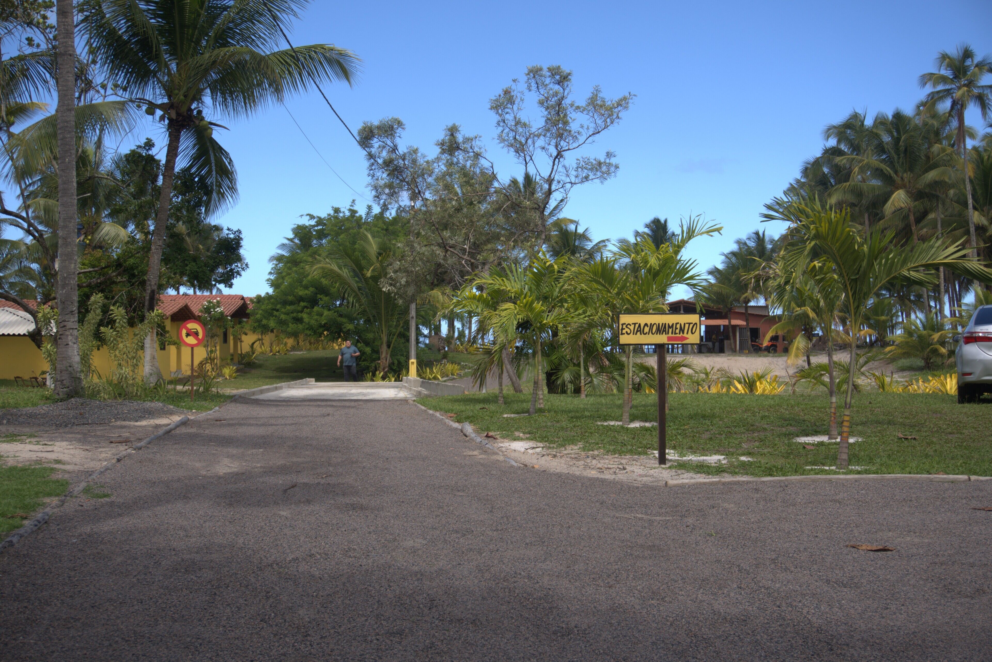 A street with a sign for 'ESTACIONAMENTO' (parking).