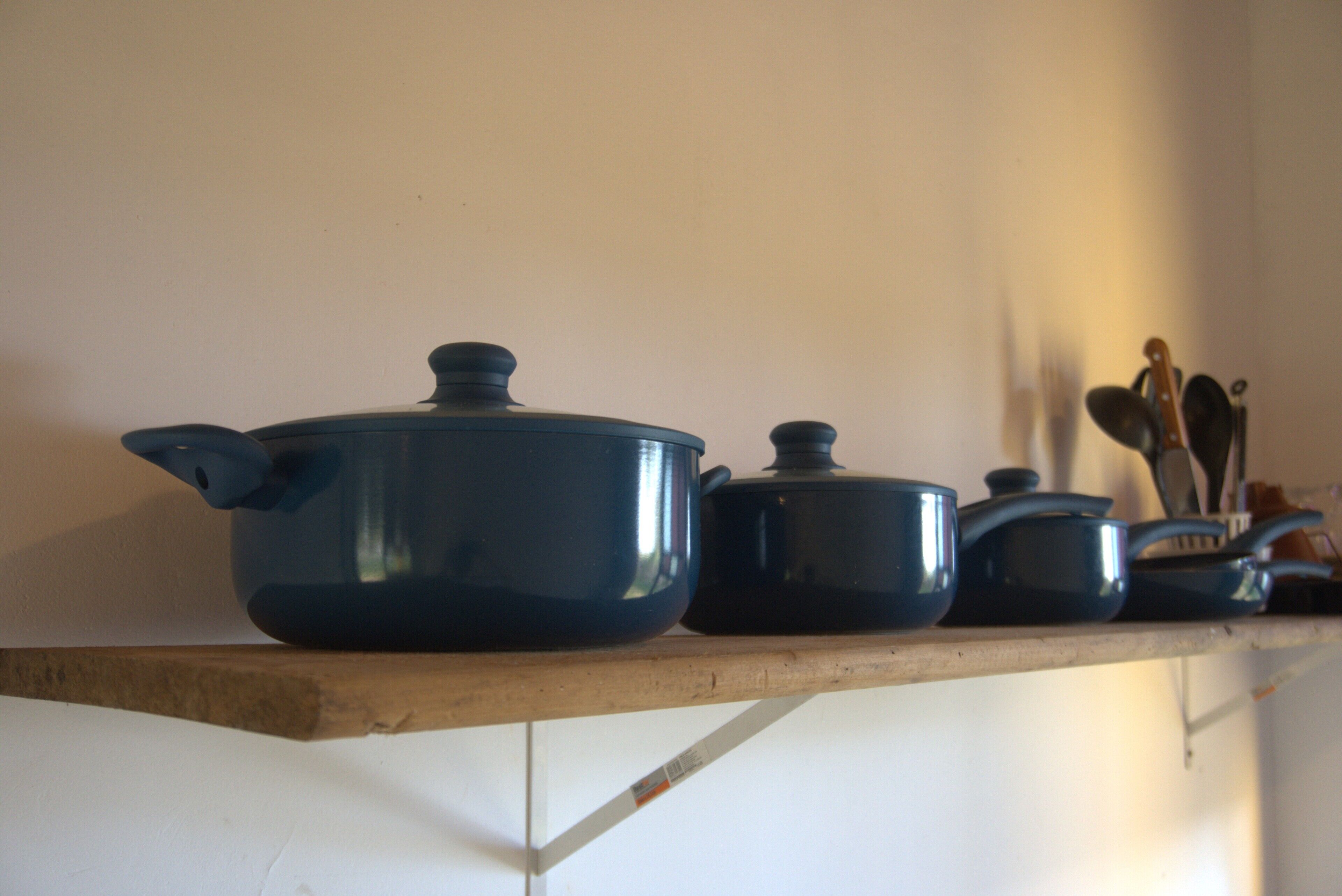 A kitchen shelf with various cookware items.