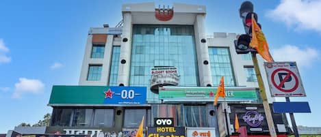 A hotel with multiple signs including 'OYO Hotel Cilantro' and 'Budget Rooms'.