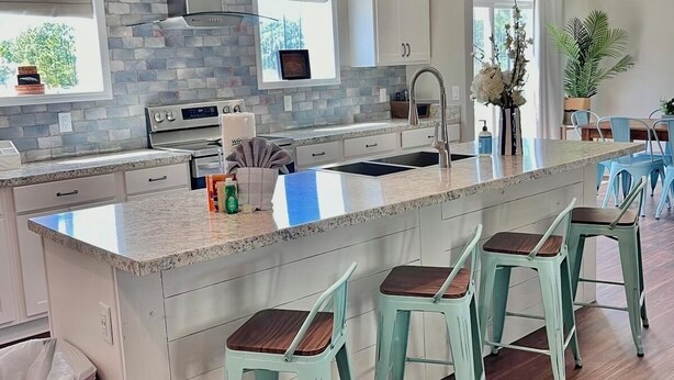 A modern kitchen with a large island, bar stools, and pendant lighting. - Seagrove-30A-3BR2BA house-bikes- beach gear- fire pit  (Santa Rosa Beach)