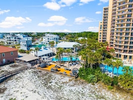 Un resort con piscina, playa y varios edificios.