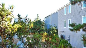En modern byggnad i två våningar med en grå fasad och vita detaljer.