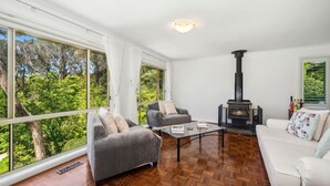 A spacious living room with a large window, a fireplace, and a sofa.