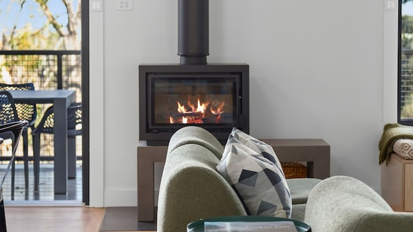 Una sala de estar acogedora con chimenea, un sofá y un comedor con mesa y sillas.