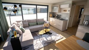 A modern living room with a sofa, a coffee table, and a dining area. - Schones Hausboot in Hoxter (Hoexter)