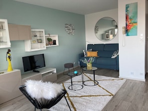 Ein modernes Wohnzimmer mit einer Couch, einem Fernseher und Dekorationselementen.