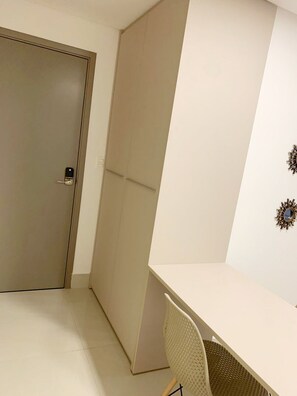 A room with a closed door, a wardrobe, a desk, and a chair. - Fortune by Day by Day (Joao Pessoa)