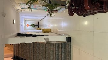 A hotel interior with a modern staircase, a reception desk, and a view into the lobby area.