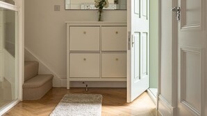 A hallway with a white cabinet, a mirror, and a door. - 3-bdr Stunning LUX Villa Parking Central London (London)
