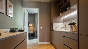 A modern kitchen with wooden flooring, built-in cabinets, and a marble backsplash. - Stylish 2-bedroom Apartment in The Hague (The Hague)