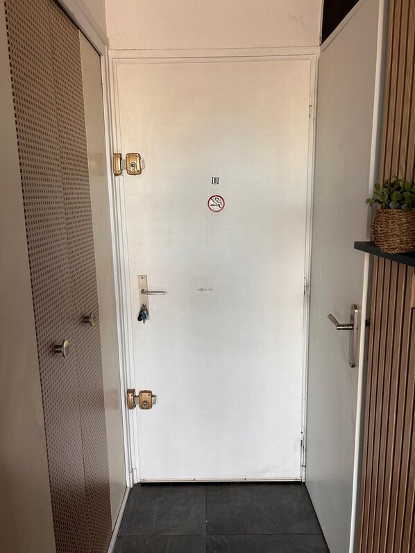 A white door with a "No Entry" sign, a keyhole, and a small window.