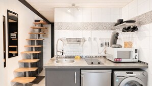 A kitchen with a built-in washing machine, a microwave, and a sink. - Naturiste Cap d'Agde Port Soleil 479 (Cap d'agde)