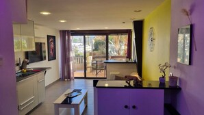 Una cocina moderna con comedor, vistas al exterior y una pared de acento morada.