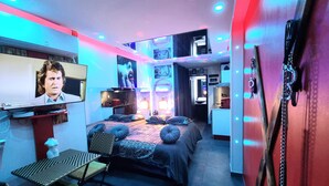 A modern hotel room with a bed, a TV, a desk, and a chair. - Naturiste Cap d'Agde Phantasme Naturiste Port Nature 94 Vue Mer (Agde)