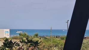 A view of the sea with boats, a pier, and some vegetation in the foreground. - Naturiste Cap d'Agde Phantasme Naturiste Port Nature 94 Vue Mer (Agde)