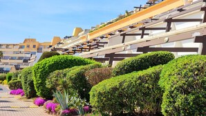 A modern building with a sloped roof and a series of balconies.
