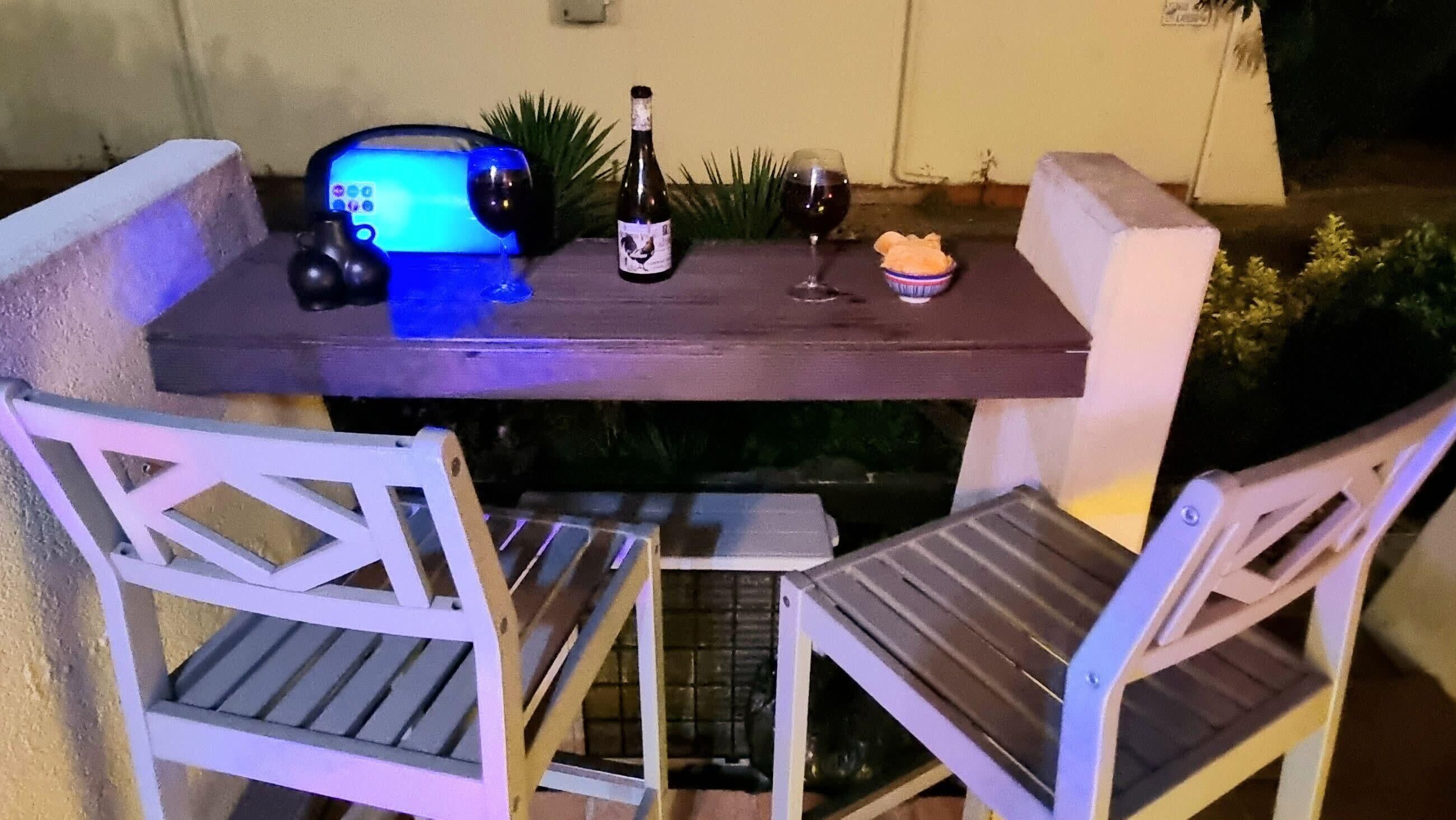 Una taula amb una ampolla de vi, un got i un bol d'aperitius.