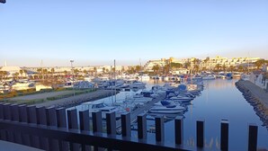 Un port de plaisance où sont amarrés de nombreux bateaux, un mur de pierre et un ciel dégagé.