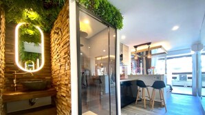 A modern kitchen with a glass partition, wooden shelves, and a built-in sink. - Naturiste Cap d'Agde Port Nature 90 (Agde)