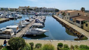 A marina with boats docked along a paved walkway. - Naturiste Cap d'Agde Port Vénus 212 (Agde)