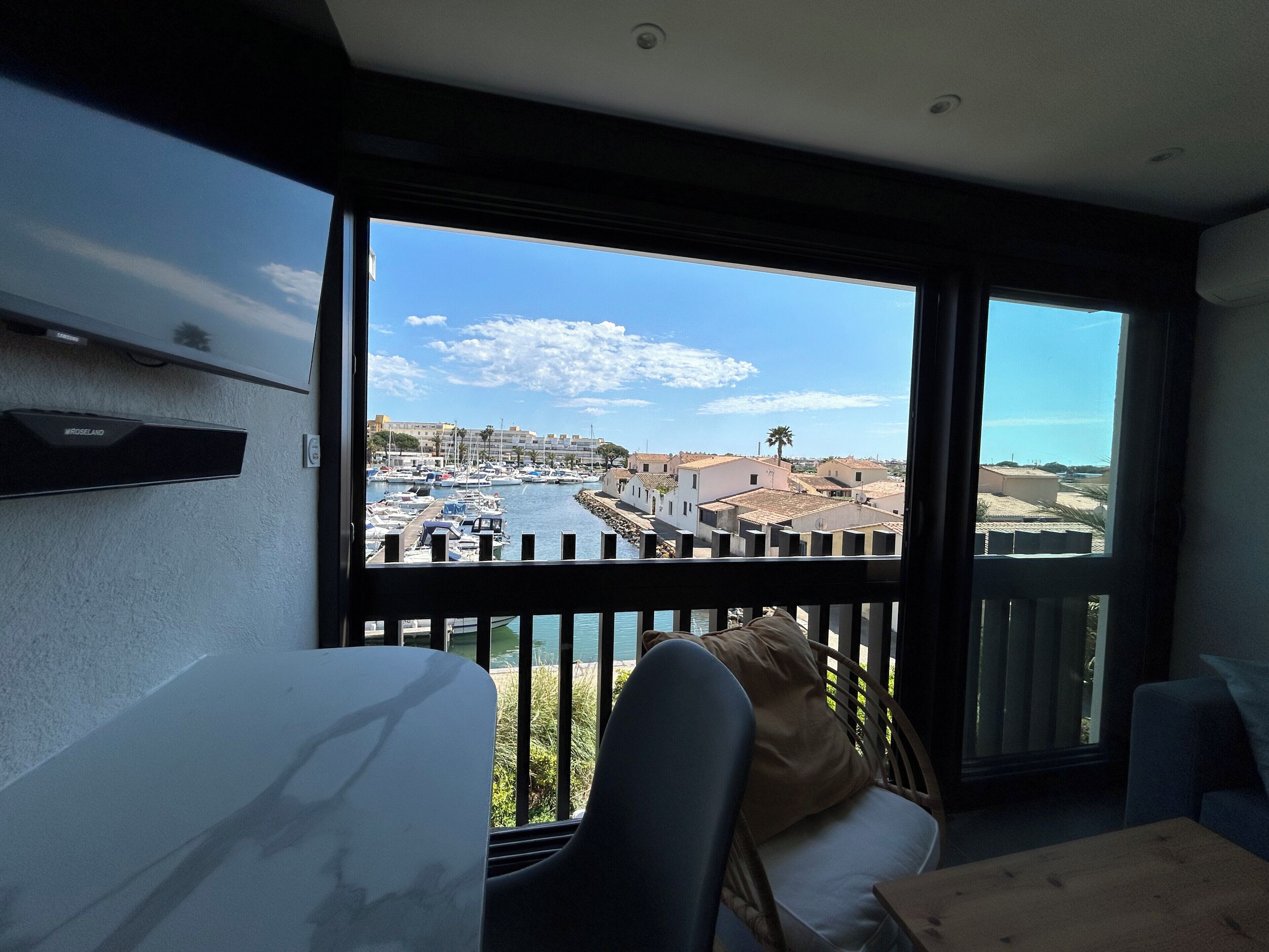 Ein Balkon mit Blick auf einen Yachthafen und Gebäude.