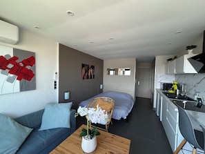 Un apartamento moderno con sala de estar, un dormitorio y una cocina.