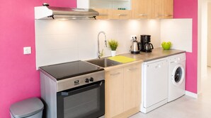 Una cocina moderna con estufa, horno, pileta y lavavajillas.