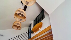 A modern interior with a staircase, wooden beams, a dining area, and a large decorative star on the wall.