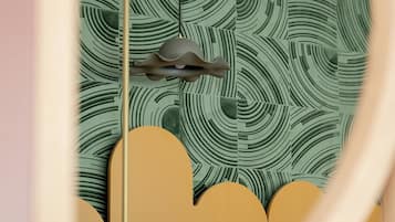 A room with a patterned wall, a ceiling fan, and a light fixture.