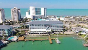 Ein Küstenhotel mit mehreren Gebäuden, einer Marina und freiem Blick auf das Meer.