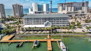 Ein Hotel mit mehreren Etagen, eine Marina voller Boote und im Hintergrund Baukräne.