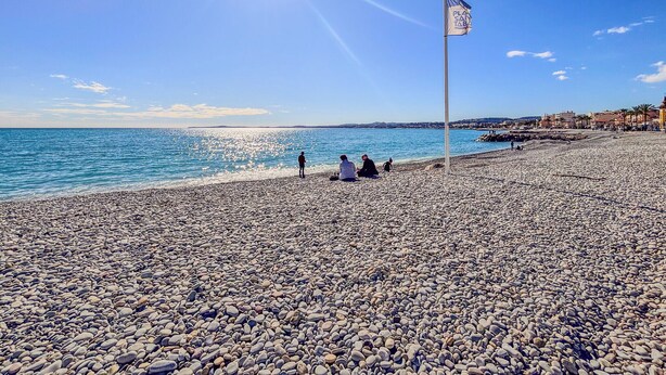 A pebbled beach with a flagpole and a clear blue sky. - Contemporary 2P Studio Just Steps from the Beach (Cagnes-sur-Mer)