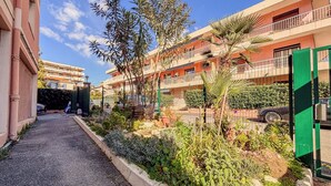A narrow alleyway with a gravel path, bordered by a variety of plants and trees. - Contemporary 2P Studio Just Steps from the Beach (Cagnes-sur-Mer)