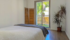 A bedroom with a bed, a sliding glass door to a balcony, and a potted plant. - Apartment for 8 guests in Nice city center (Nice)