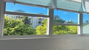 A room with a large window, white walls, and an air conditioning unit. - Cozy Studio in CostaMar Beach Village PR (Medianía Alta)