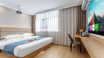 A hotel room with a bed, a desk, a chair, a TV, and curtains.
