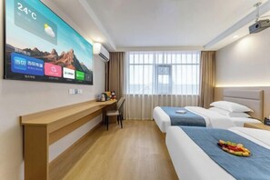 Een hotelkamer met een bed, een bureau, een stoel, een televisie waarop een berglandschap te zien is, en een raam met gordijnen.