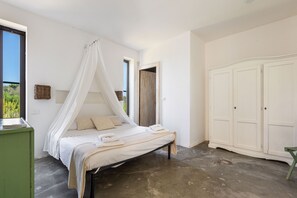Ein Schlafzimmer mit Bett, Schrank und Fenster.