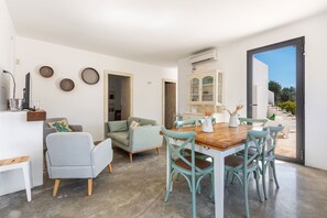 Un intérieur moderne comprenant un coin repas, un canapé et un meuble.